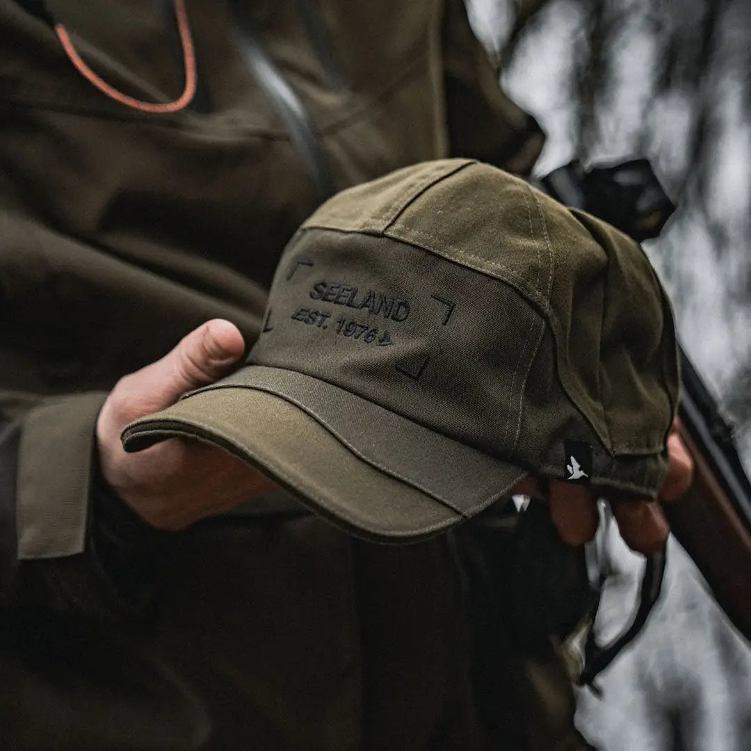 Olive green Seeland Trax Cap with REELAMO EST. 1975 embroidered on the front