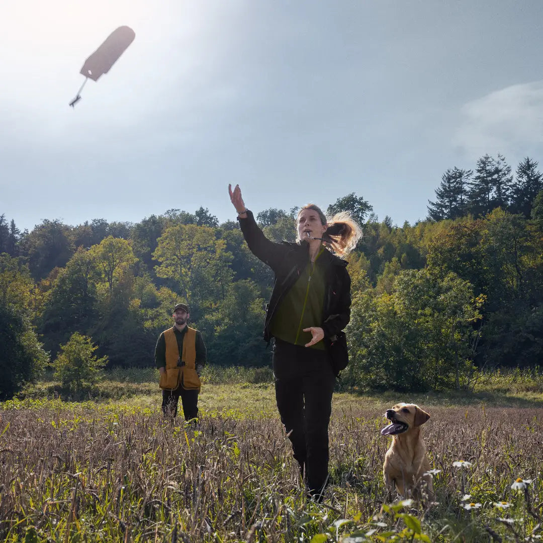 Person in Seeland Dog Active Jacket reaching for a floating microphone with a dog