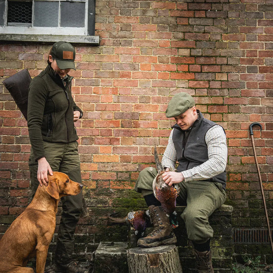 Two men in traditional hunting gear with a dog wear Seeland Woodcock Earl Fleece Waistcoat