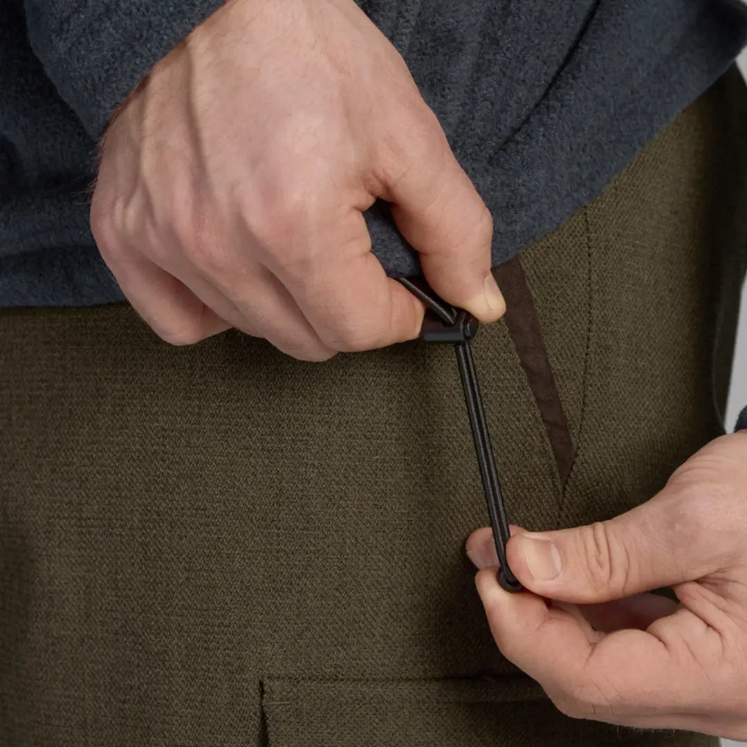 Hands using scissors to cut fabric for Seeland Woodcock Fleece, perfect for shooting parties