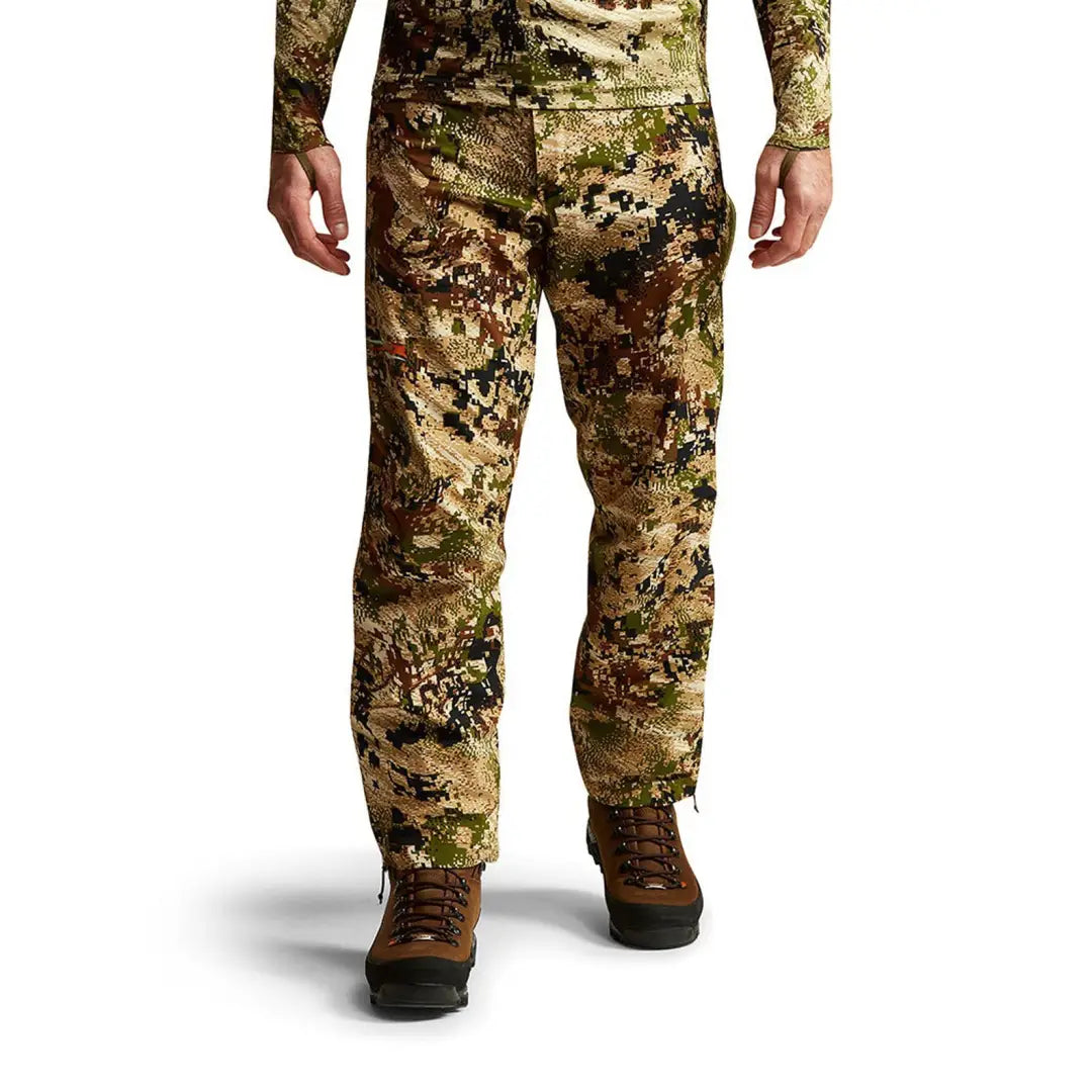 Camouflage Sitka Dew Point Pants paired with brown boots for style and function