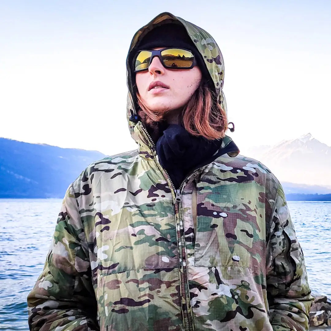 Camouflage Arrowhead Technical Insulated Jacket worn by a person in sunglasses by water