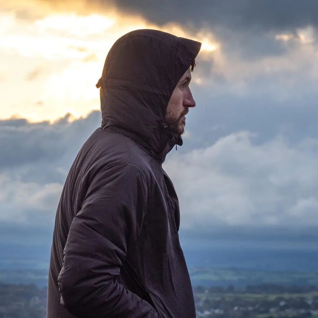 Person in a Snugpak Arrowhead Technical Insulated Jacket gazing at a cloudy sky