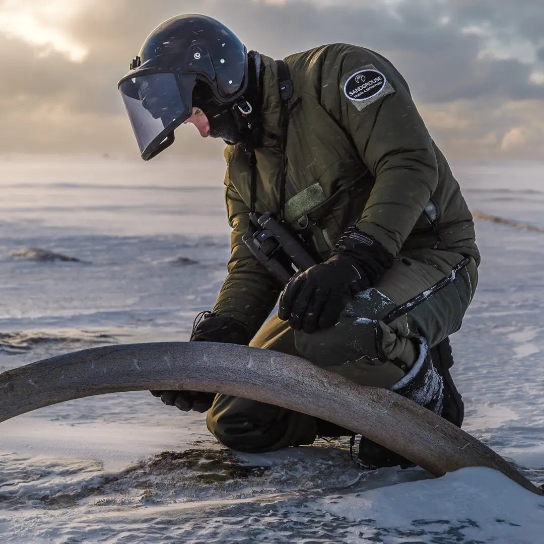 Military pilot in Snugpak Salopettes Reversible, working on aircraft in icy conditions