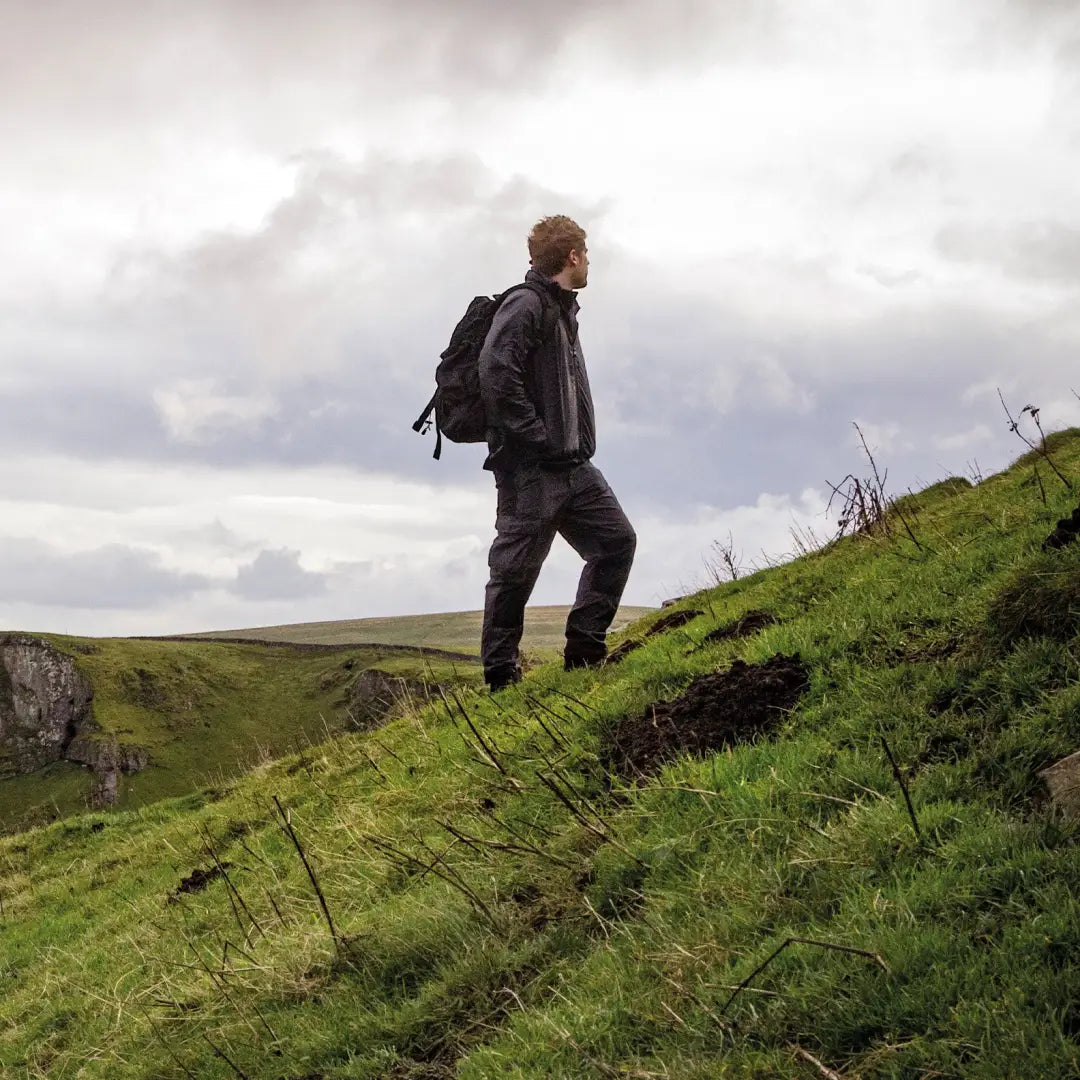 Hiker with Snugpak Sleeka Force 35L Daypack on grassy hillside showcasing intelligent design