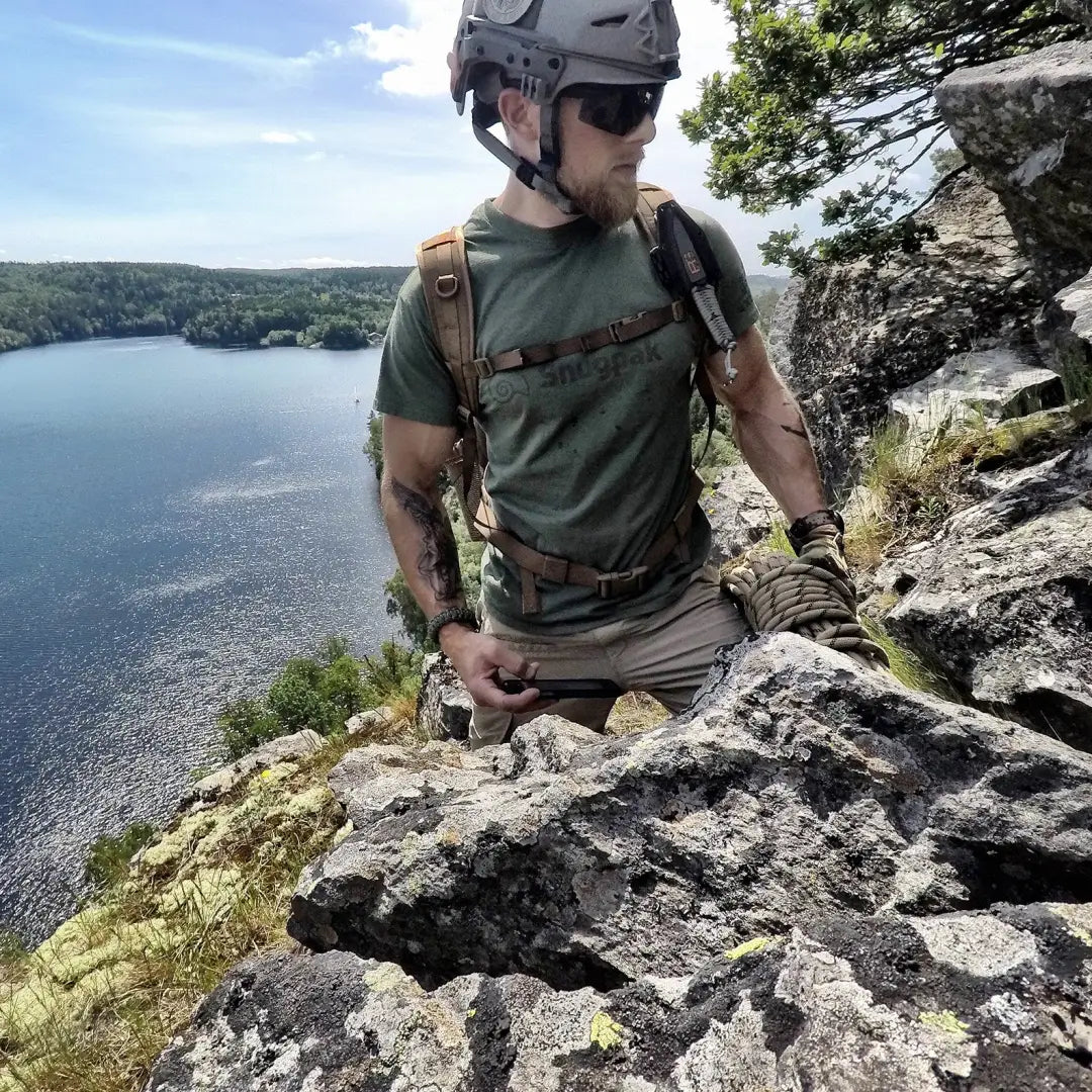 Rock climber in Snugpak T-Shirt, embracing outdoors and country clothing vibes by a lake