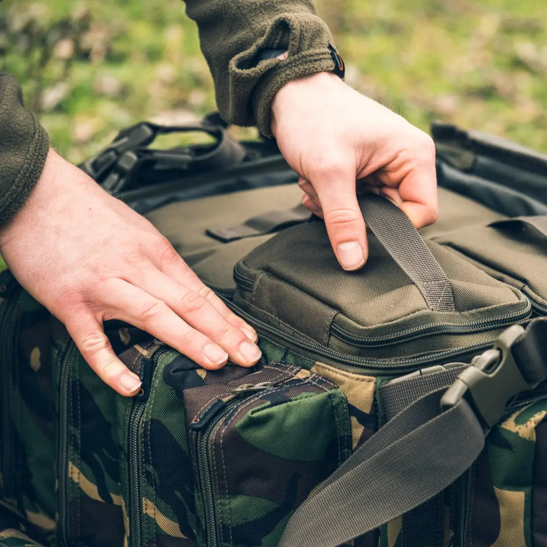 Hands opening a Speero Modular Bait Bag with camouflage pattern and hook bait pockets