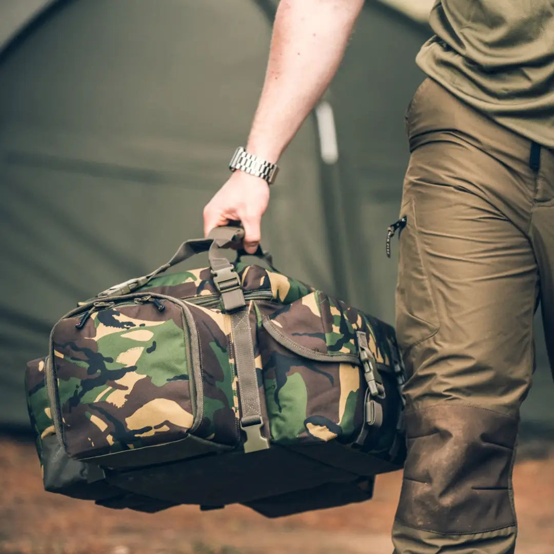 Camouflage-patterned Speero Modular Carryall duffel bag being carried by hand