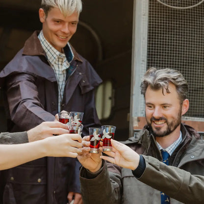 Group of people celebrating with drinks while wearing Stockman Full Length Wax Coat