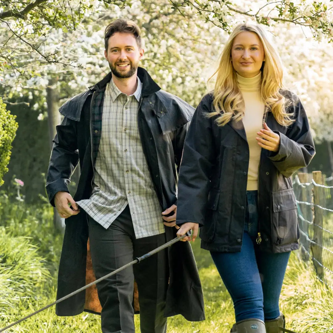 Couple enjoying spring weather in a Wax Stockman Coat during a sunny outdoor stroll