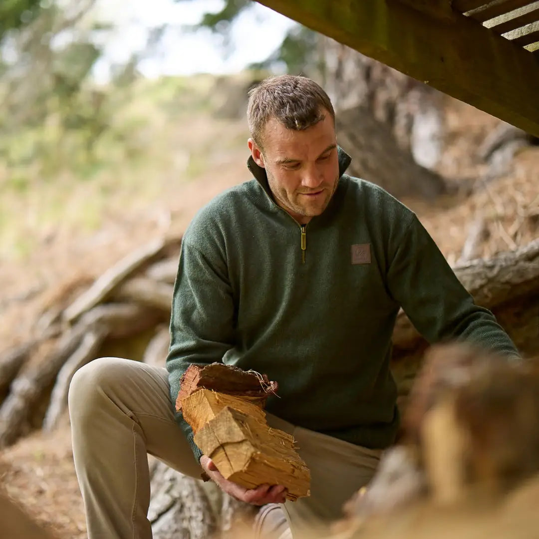 Man in a Mariner Zip Neck pullover jumper holding firewood outdoors