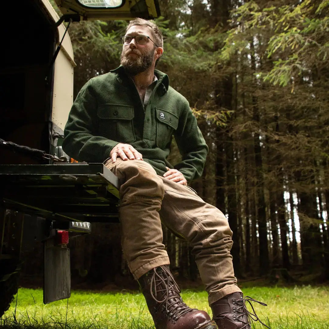 Bearded man in Swanndri Ranger Extreme V2 outfit sitting on a vehicle in the forest