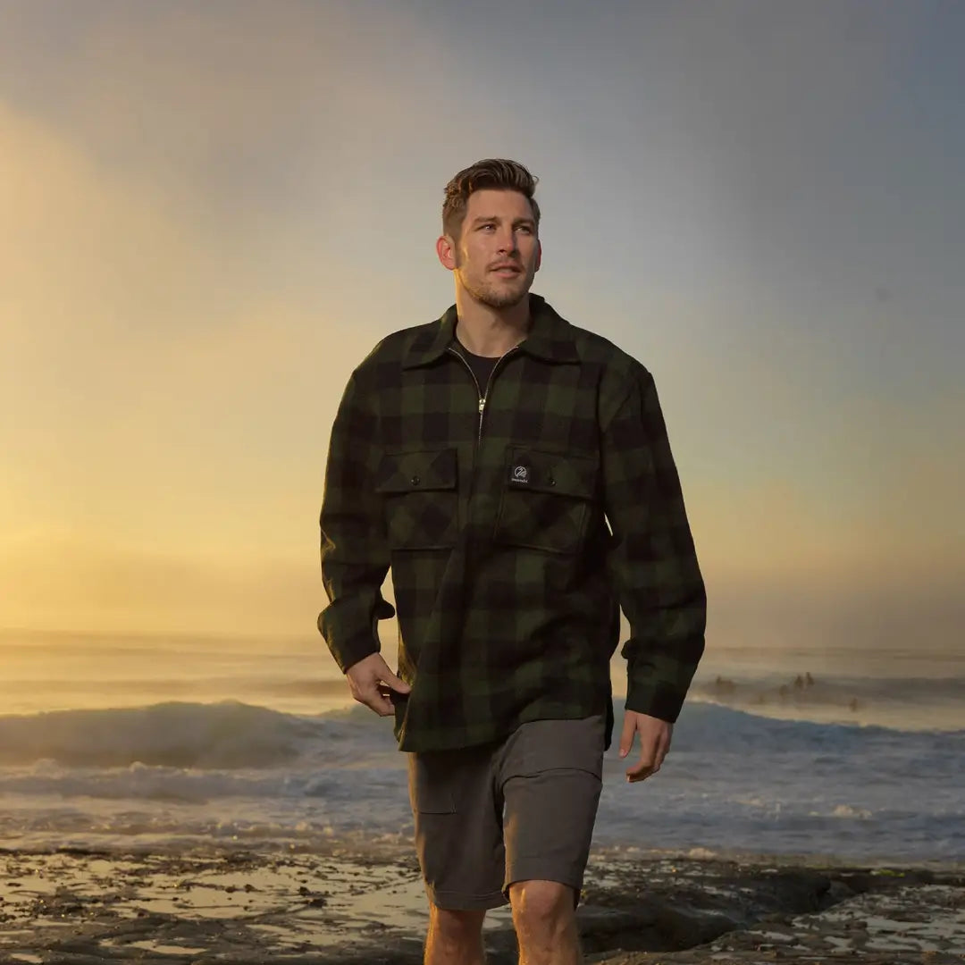 Man in a plaid jacket and shorts enjoying the beach in a Ranger Bush Shirt