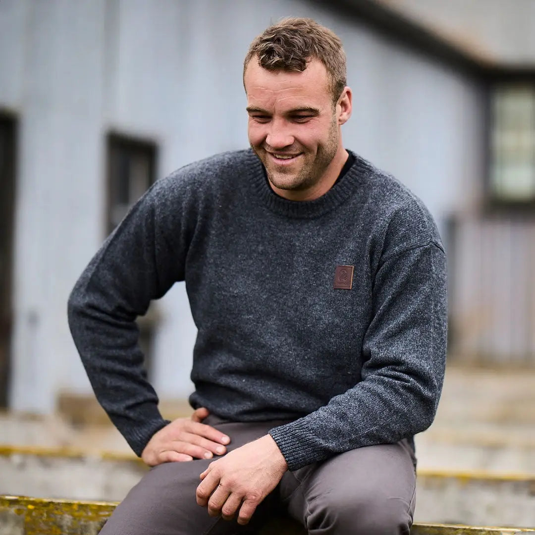 Man in dark gray sweater smiling outdoors in stylish country clothing from Swanndri