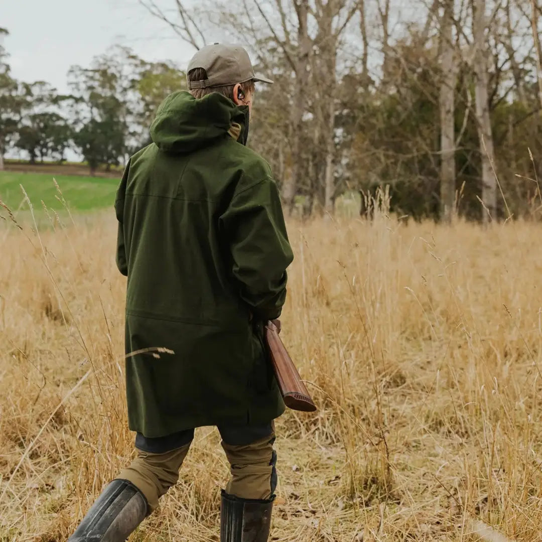 Outdoors person wanting stylish Wapiti coat in high-performance rain wear in tall grass