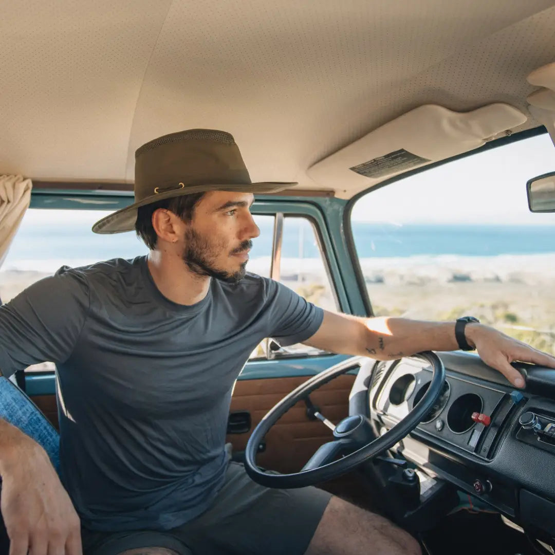 Man in a Tilley LTM6 Airflo Hat driving by the beach in a vehicle