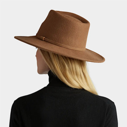 Brown wide-brimmed fedora on a person with blonde hair wearing a Tilley Jasper Hat