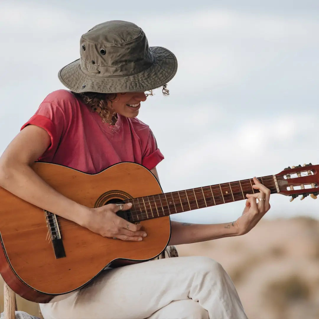 Acoustic guitar jam session featuring a person in a red shirt and Tilley T3 Wanderer Hat