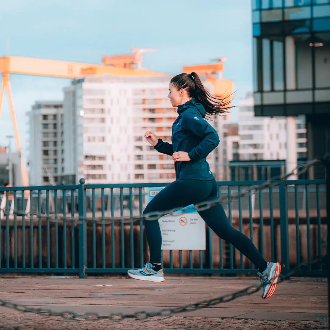 Woman running on urban bridge in a Venture Ultralight Ladies Performance Running Jacket