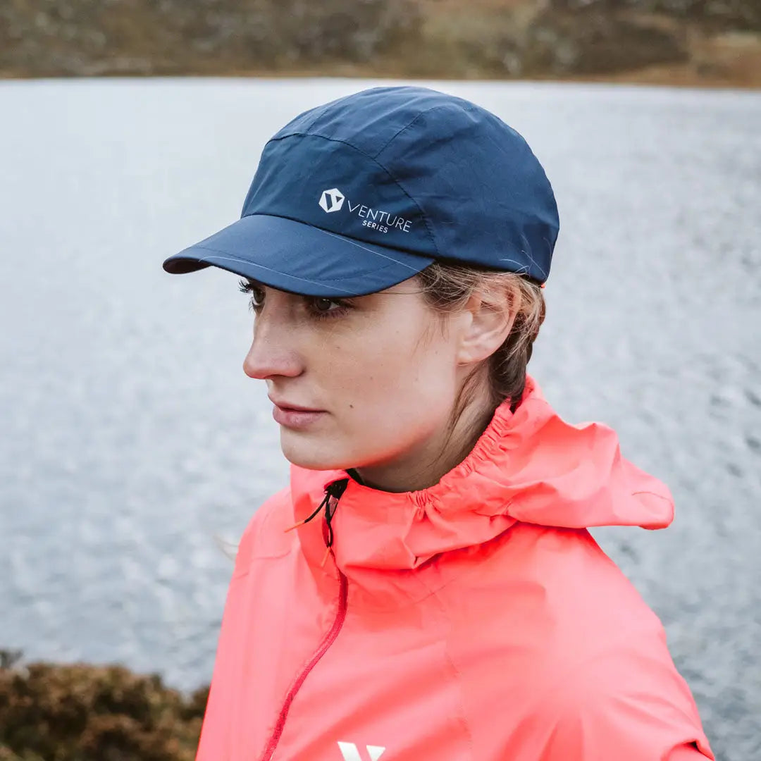 Woman in navy blue baseball cap and coral jacket, perfect for country clothing and outdoors