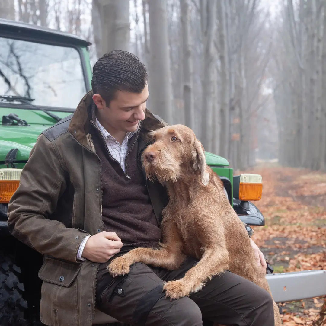 Man in a Verney Carron Fox Original Jacket with a golden dog on his lap