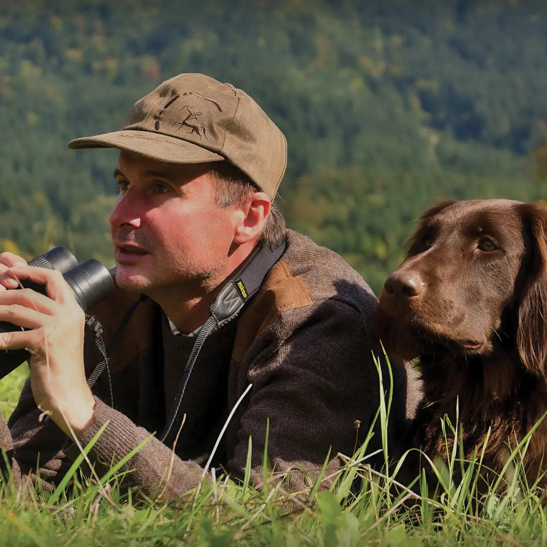 Man with binoculars and brown dog in grass, wearing Verney Carron Fox Round Neck Pullover