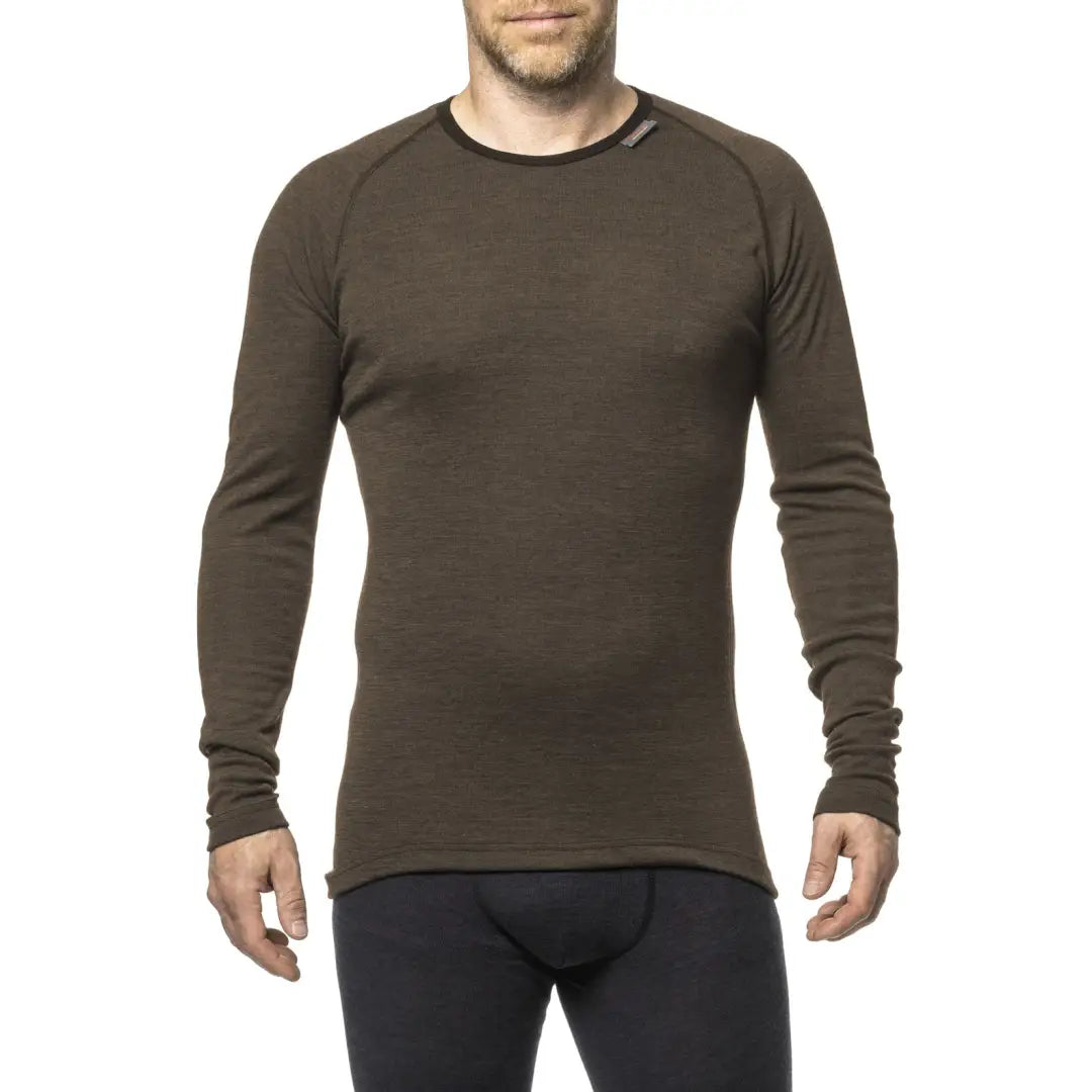 Person wearing a Long-sleeved brown Woolpower LITE Unisex Crewneck for country clothing